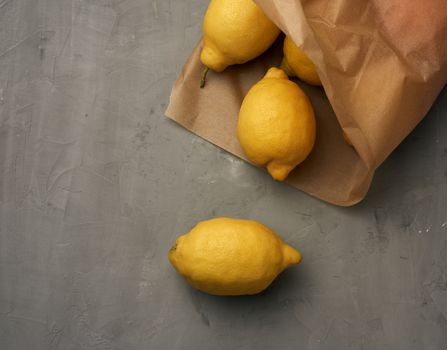 ripe yellow lemons on a gray table, ingredient for lemonade, top view