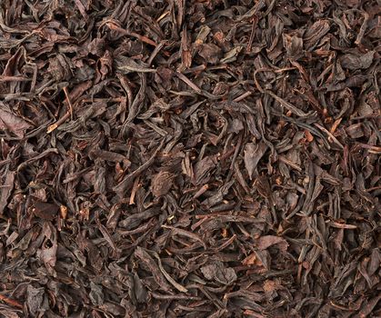 texture of dry black long leaf tea, top view, ingredients for a hot drink, close up