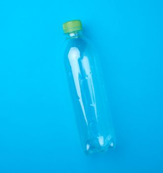 empty transparent plastic bottle on a blue background, top view