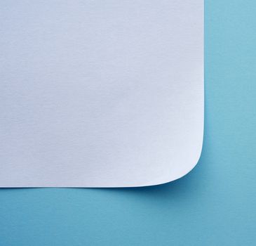wrapped sheet of white paper on a blue background, macro, top view