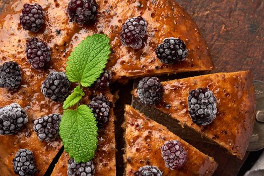 baked sweet round biscuit cake with nuts and berries topped, top view