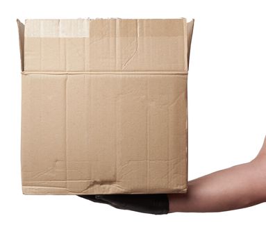 male hand in a black latex glove holds an open brown cardboard box on a white background, safe and contactless delivery of on-line orders during epidemics