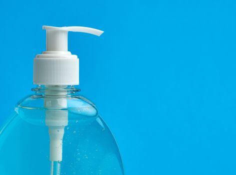 transparent plastic bottle with a sanitizer for disinfecting hands on a blue background, a place for inscription