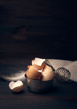 brown raw chicken shell in an iron bowl on a wooden table, vintage toning, copy space