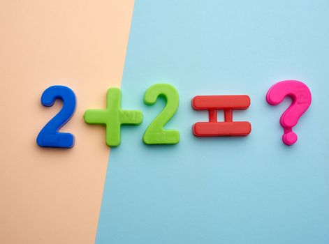 math example two plus two equals of colorful plastic numbers, view from above, back to school