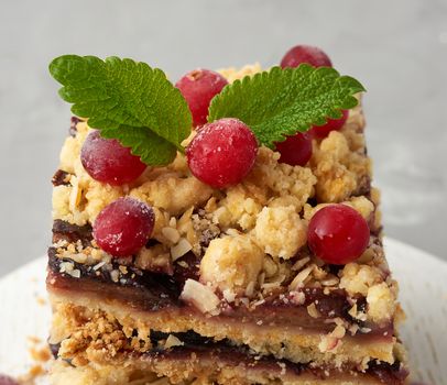 stack of square slices of baked crumble pie with blue plum, delicious dessert, close up