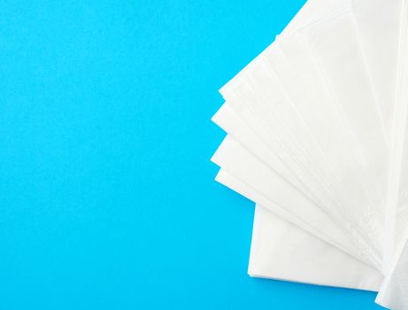 stack of white paper napkins on a blue background, place for inscription