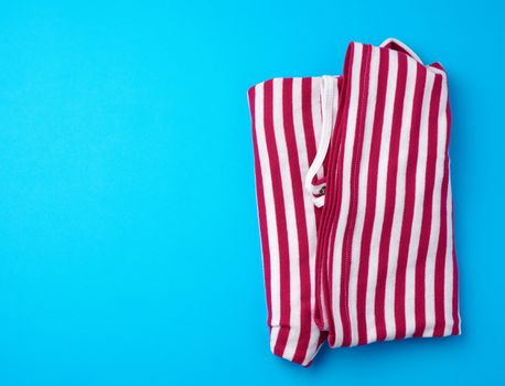 red striped folded clothes on a blue background, top view