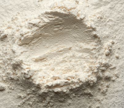 white wheat flour scattered, top view, funnel for liquid ingredients, close up