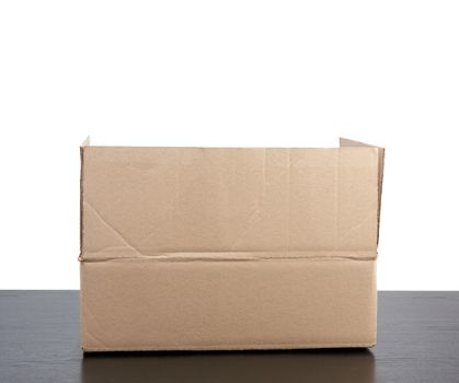 open cardboard box stands on a black table, white isolated background, concept of moving and packing goods