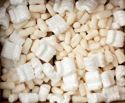 open brown cardboard box with white foam filling for transporting goods, top view
