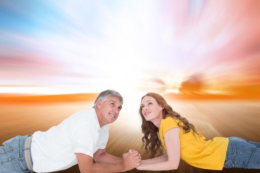Casual couple lying and looking up against field with light wave