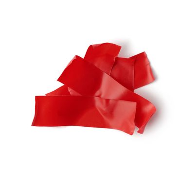 various pieces of red insulating rubber tape isolated on a white background, close up