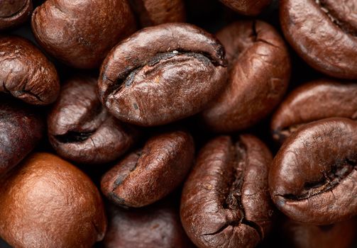 roasted grains of Robusta coffee on a black background, top view, full frame