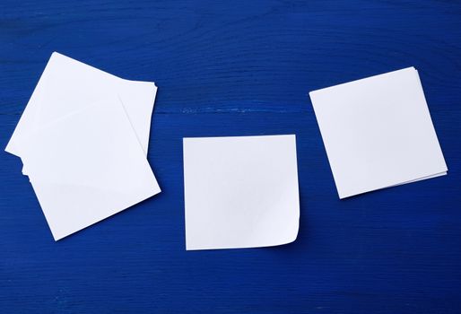 empty white sheet of paper on a blue wooden background, copy space