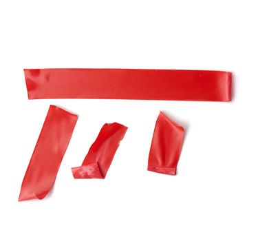 various pieces of red insulating rubber tape isolated on a white background, close up