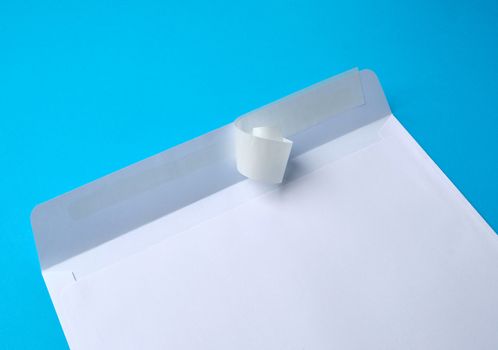 white rectangular blank paper envelope on a blue background, flat lay
