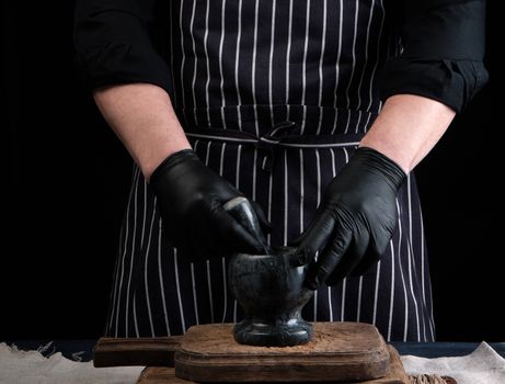 chef man holding a stone mortar and pestle for grinding spices, low key