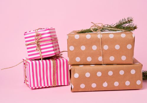 stack of colored paper wrapped gift boxes. great design for any purposes. pink background 