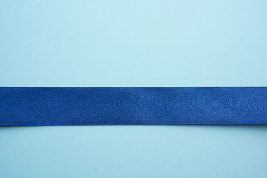 blue silk ribbon on a blue background, festive backdrop, place for text
