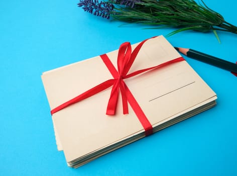 tied red silk ribbon rectangular vintage greeting card, blue background, top view