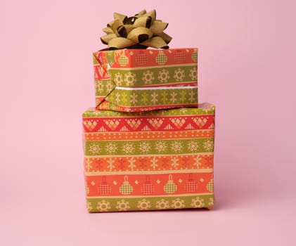 stack of colored paper wrapped gift boxes. great design for any purposes. pink background 