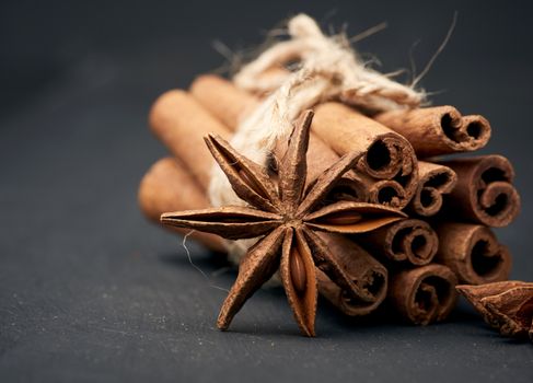 dry star anise with a bunch of brown cinnamon sticks tied with a rope, close up