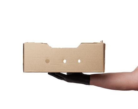 male hand in a black latex glove holds an empty brown cardboard box on a white background, safe and contactless delivery of on-line orders during epidemics