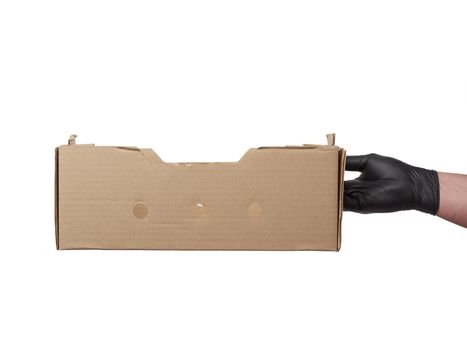 male hand in a black latex glove holds an empty brown cardboard box on a white background, safe and contactless delivery of on-line orders during epidemics