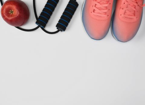 sports textile shoes and other items for fitness on a white background, top view, copy space