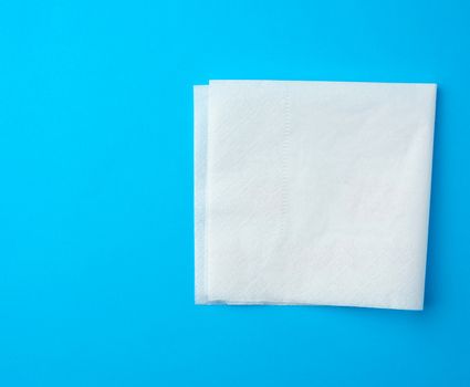 white paper napkins on a blue background, place for inscription, top view