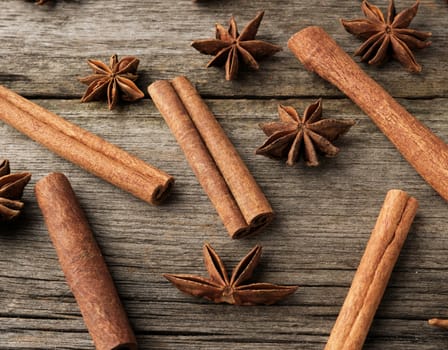 brown cinnamon sticks and dry star anise on a gray wooden background, tasty and fragrant spice, top view