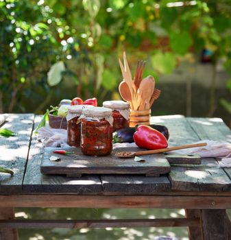 canned eggplant with vegetables on a brown wooden board, close up, outdoor 