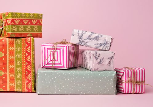 stack of colored paper wrapped gift boxes. great design for any purposes. pink background 