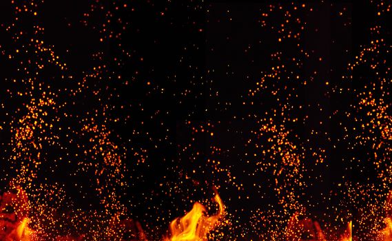 large burning bonfire with flame and orange sparks that fly in different directions on a black background, full frame