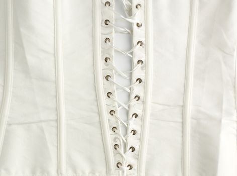 fragment of a white satin corset with lacing, wrong side of clothes