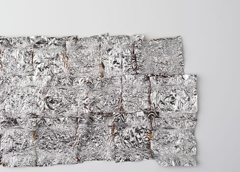 texture of crumpled candy wrappers, foil on a white background, close up