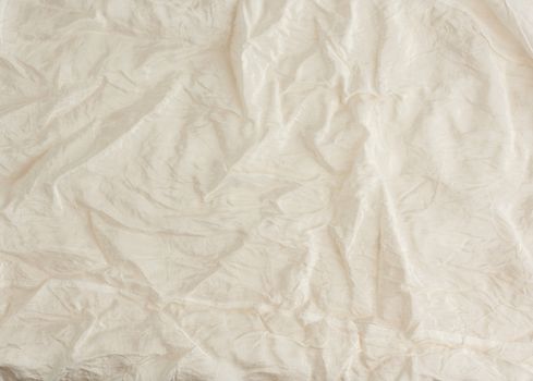 crumpled beige synthetic fabric for the manufacture of lining for skirts, full frame