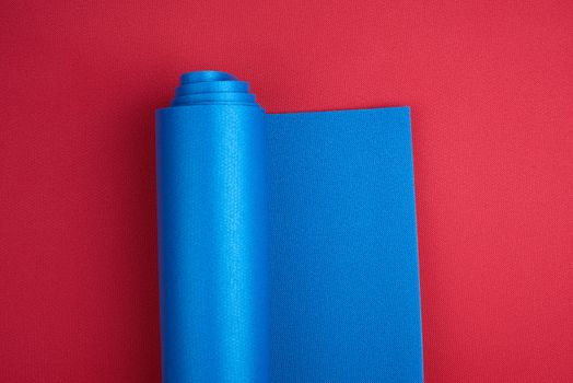 neoprene blue twisted mat lies on a red background, sports equipment, copy space