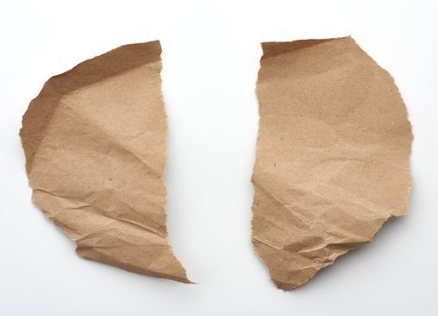 fragment of crumpled blank sheet of brown wrapping kraft paper with torn edges, vintage texture for the designer, white background