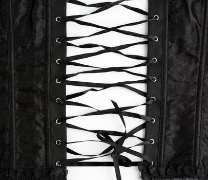 fragment of a black satin corset with lacing, back view, clothing item on a white background