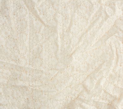 texture of crumpled beige synthetic fabric guipure for sewing clothes, full frame