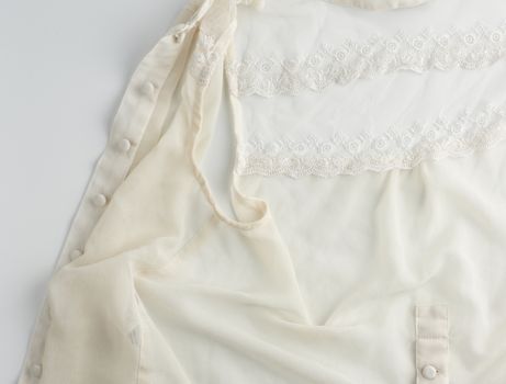 fragment of a silk beige blouse with lace and buttons, close up