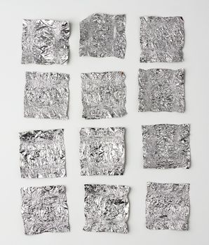 various crumpled foil used candy wrappers on a white background, top view
