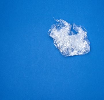 crumpled transparent stretching plastic film for packaging products on a blue background, close up