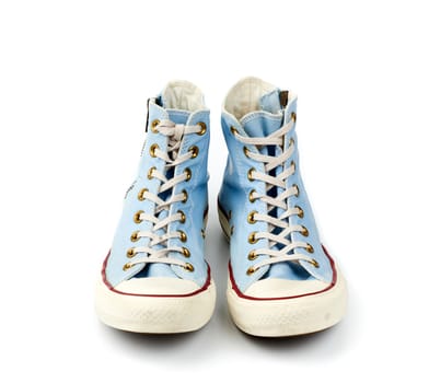 pair of light blue worn textile sneakers with laces and zippers on a white background, front view