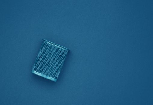 empty blue metal bin for paper, dark blue background, business concept
