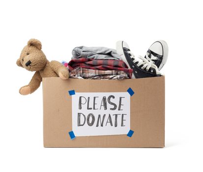 brown cardboard box with a white sheet pasted and the inscription please donate on a white background, inside clothes, toys, help concept