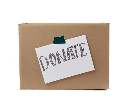 brown cardboard box with a pasted white sheet and the inscription donate on a white background, help concept