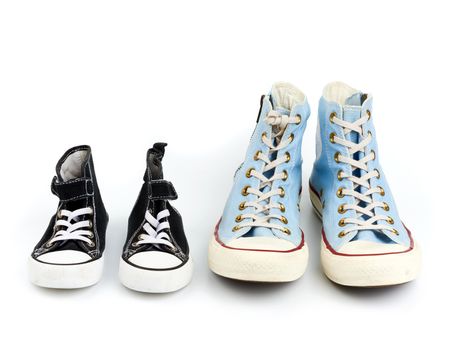 two pairs of textile sneakers with white laces on a white background, shoes of a child and an adult